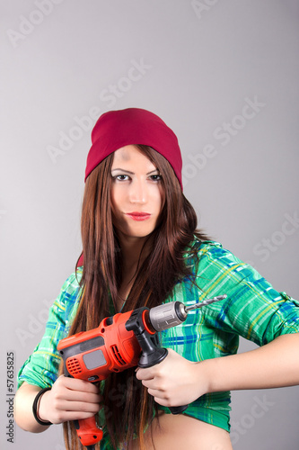 Photo: young woman holding a power tool young woman holding a power tool