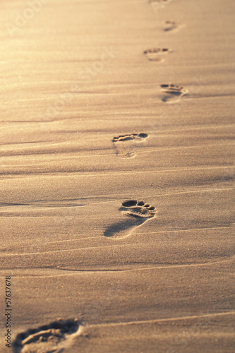 Naklejka na szybę Close up of footprints on the beach sand at the sunset with copy