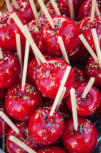 Photo: Candied apples with wooden sticks and sprinkles Candied apples with wooden sticks and sprinkles