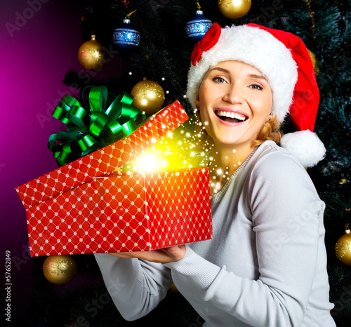 Photo: Happy laughing woman holds the christmas box with gifts Happy laughing woman holds the christmas box with gifts