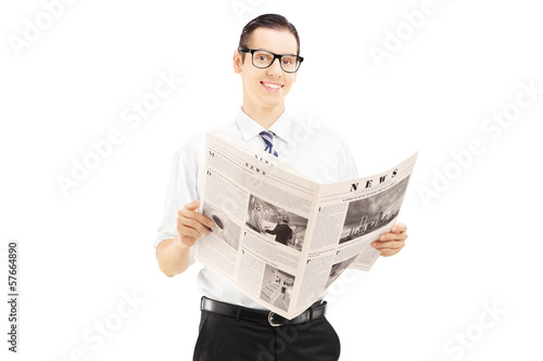 Photo: Young businessperson standing and reading a newspaper Young businessperson standing and reading a newspaper