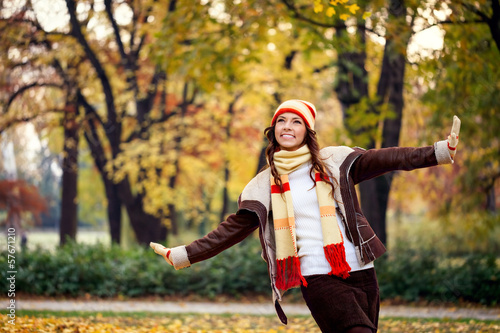 Photo: Young woman playing in autumn park Young woman playing in autumn park