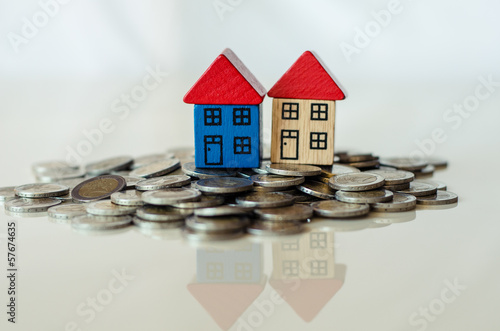 Photo: coins and houses standing on it coins and houses standing on it