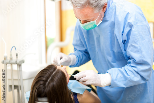 Photo: Dentist doing a treatment Dentist doing a treatment
