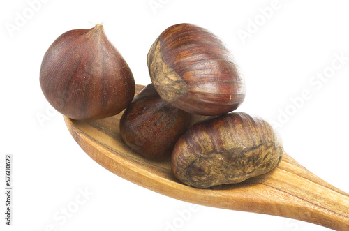 Photo: Wooden spoon with chestnuts close up on the white Wooden spoon with chestnuts close up on the white