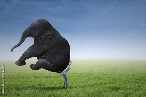 Photo: Woman lifting heavy elephant Woman lifting heavy elephant