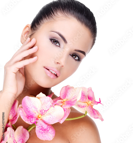 Photo: Beautiful face of woman with healthy skin and pink flowers Beautiful face of woman with healthy skin and pink flowers