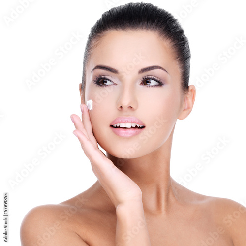 Photo: Young woman with cosmetic cream on face Young woman with cosmetic cream on face