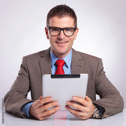 Photo: young business man with tablet smiles for you young business man with tablet smiles for you