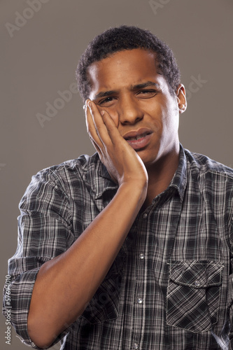 Photo: young African American young man with a strong toothache young African American young man with a strong toothache