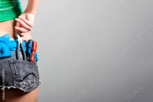 Photo: female worker with pliers and screwdrivers in back pocket female worker with pliers and screwdrivers in back pocket
