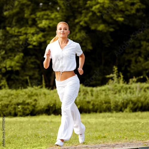 Photo: Athletic Runner Training in a park for Marathon. Fitness Gir Athletic Runner Training in a park for Marathon. Fitness Gir