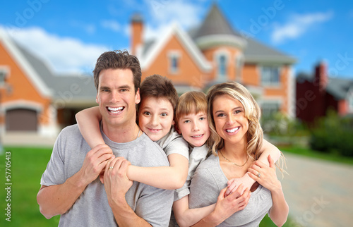 Photo: Happy family near new home. Happy family near new home.