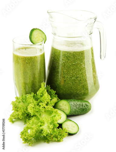 Photo: Glass and jug of green vegetable juice with cucumber isolated Glass and jug of green vegetable juice with cucumber isolated