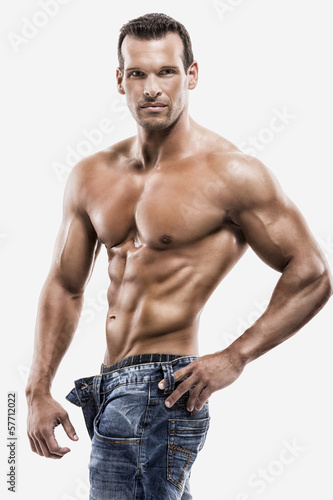 Photo: Muscle man posing in studio, isolated over a white background Muscle man posing in studio, isolated over a white background