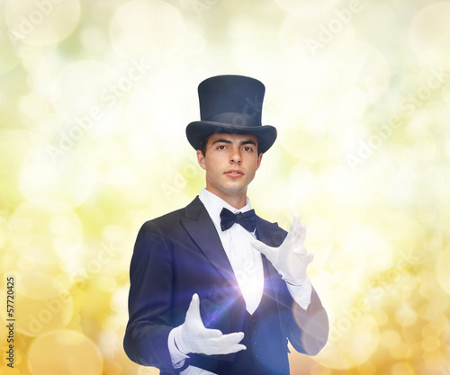 Photo: magician in top hat showing trick magician in top hat showing trick