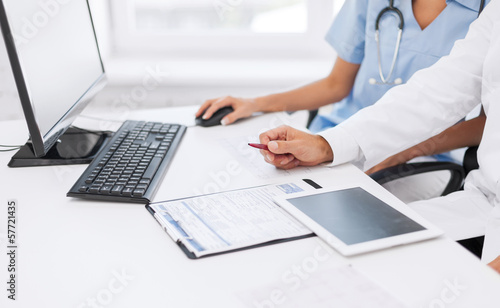 Photo: group of doctors looking at tablet pc group of doctors looking at tablet pc