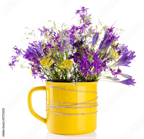 Photo: Beautiful bouquet of wildflowers in cup, isolated on white Beautiful bouquet of wildflowers in cup, isolated on white