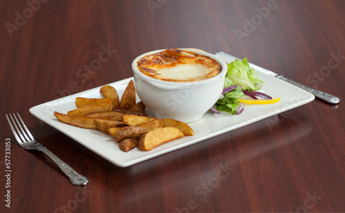 Photo: Side view of lasagna with salad and potatoes Side view of lasagna with salad and potatoes