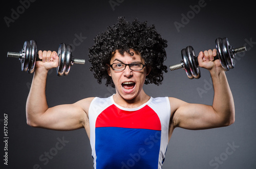 Photo: Funny man exercising with dumbbells Funny man exercising with dumbbells