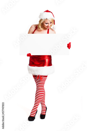 Photo: attraktive blonde Weihnachtsfrau mit Schild als Textfreiraum attraktive blonde Weihnachtsfrau mit Schild als Textfreiraum