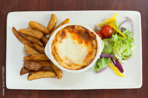 Photo: Overhead view of lasagna with potatoes and salad Overhead view of lasagna with potatoes and salad