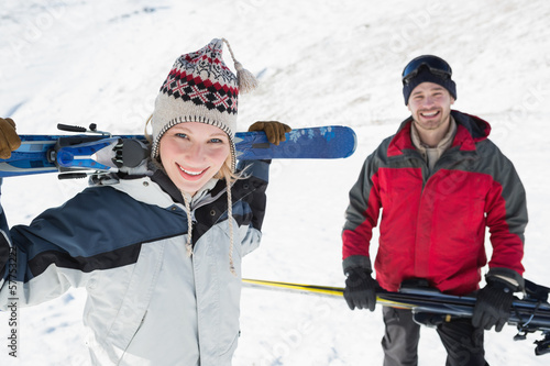 Photo: Portrait of a smiling couple with ski boards on snow Portrait of a smiling couple with ski boards on snow