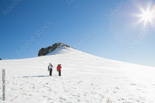 Photo: Skiers walking on snow on a sunny day Skiers walking on snow on a sunny day