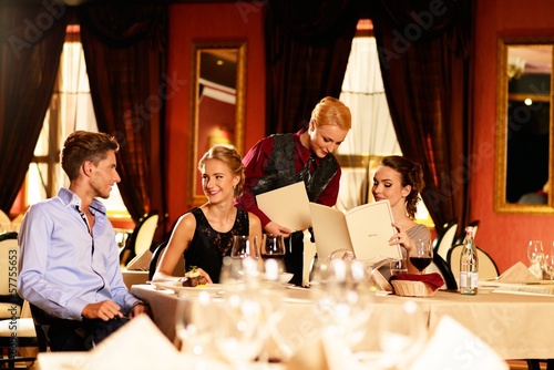 Photo: Group of young friends with choosing in a luxury restaurant Group of young friends with choosing in a luxury restaurant