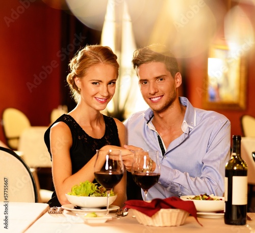 Photo: Beautiful young couple with glasses of red wine Beautiful young couple with glasses of red wine