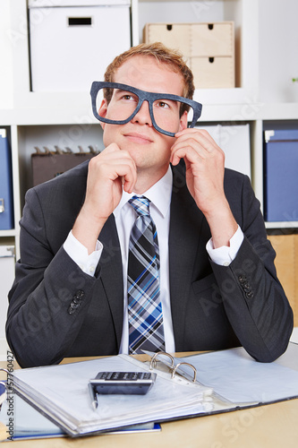 Photo: Nerd im Büro schaut nachdenklich Nerd im Büro schaut nachdenklich