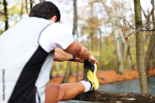 Photo: Junger Mann dehnt sich vor Sport Junger Mann dehnt sich vor Sport