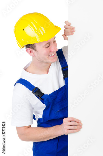 Photo: Bauarbeiter schaut auf Werbeschild Bauarbeiter schaut auf Werbeschild
