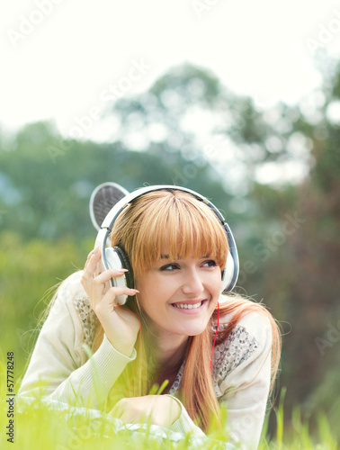 Photo: Beautiful young woman with headphones. Enjoy music outdoors Beautiful young woman with headphones. Enjoy music outdoors