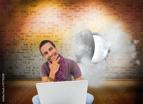 Photo: Composite image of thinking man sitting on floor using laptop an Composite image of thinking man sitting on floor using laptop an