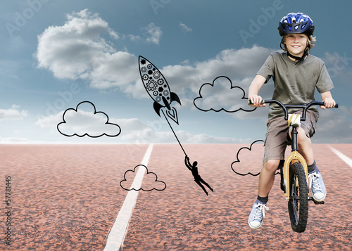 Photo: Composite image of little boy with his bike in a park Composite image of little boy with his bike in a park