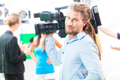 Photo: Cameraman shooting with camera on film set Cameraman shooting with camera on film set