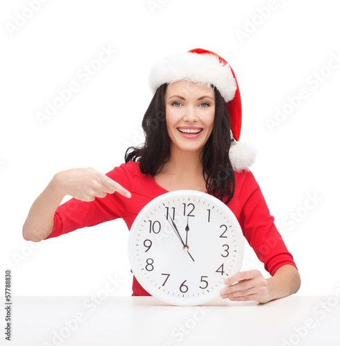 Photo: woman in santa helper hat with clock showing 12 woman in santa helper hat with clock showing 12