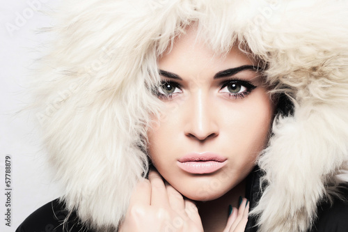 Photo: young beautiful woman with fur. white fur hood. winter style young beautiful woman with fur. white fur hood. winter style