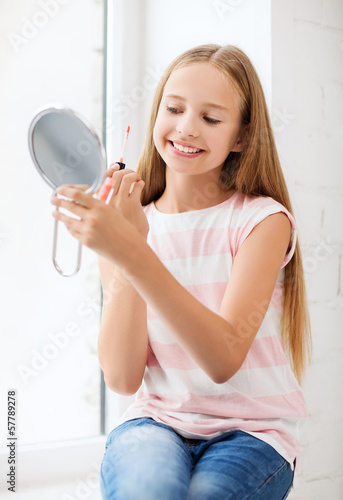 Photo: teenage girl with lip gloss and mirror teenage girl with lip gloss and mirror