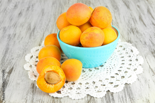 Photo: Fresh natural apricot in bowl on green wooden table Fresh natural apricot in bowl on green wooden table