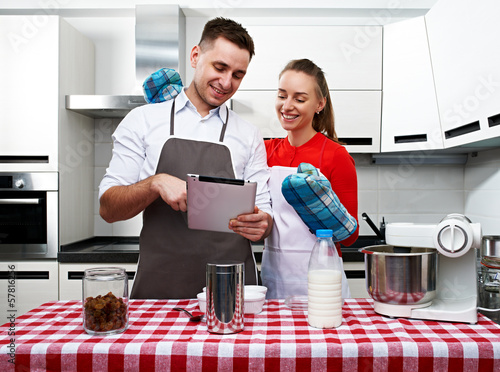 Photo: Couple at kitchen with tablet pc Couple at kitchen with tablet pc