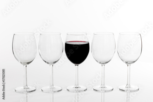 Photo: Glass of red wine in a row of empty glasses Glass of red wine in a row of empty glasses