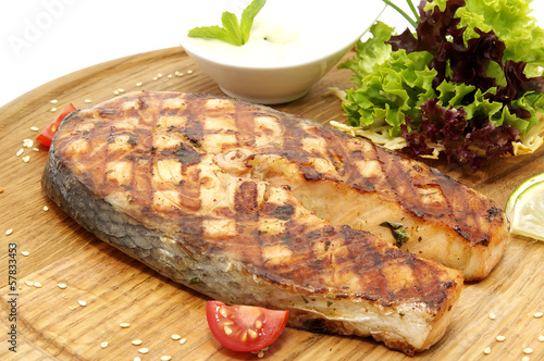 Photo: Grilled salmon on a plate with greens Grilled salmon on a plate with greens