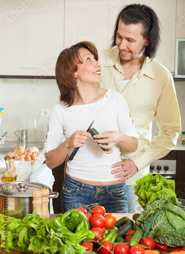 Photo: A man and a woman with vegetables in the kitchen A man and a woman with vegetables in the kitchen