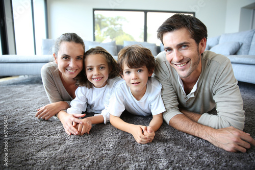 Photo: Family at home relaxing on carpet Family at home relaxing on carpet