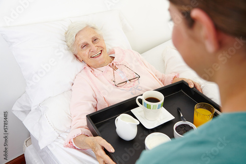 Photo: Seniorin im Pflegeheim bekommt Frühstück ans Bett Seniorin im Pflegeheim bekommt Frühstück ans Bett