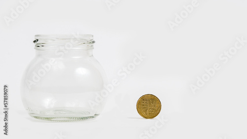 Photo: pound coin by empty jar pound coin by empty jar