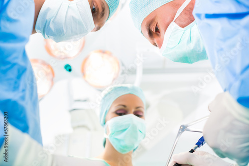 Photo: Chirurgen operieren in OP-Saal an Patienten Chirurgen operieren in OP-Saal an Patienten