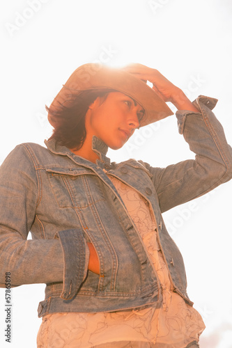 Photo: Woman in hat against the sunny sky Woman in hat against the sunny sky